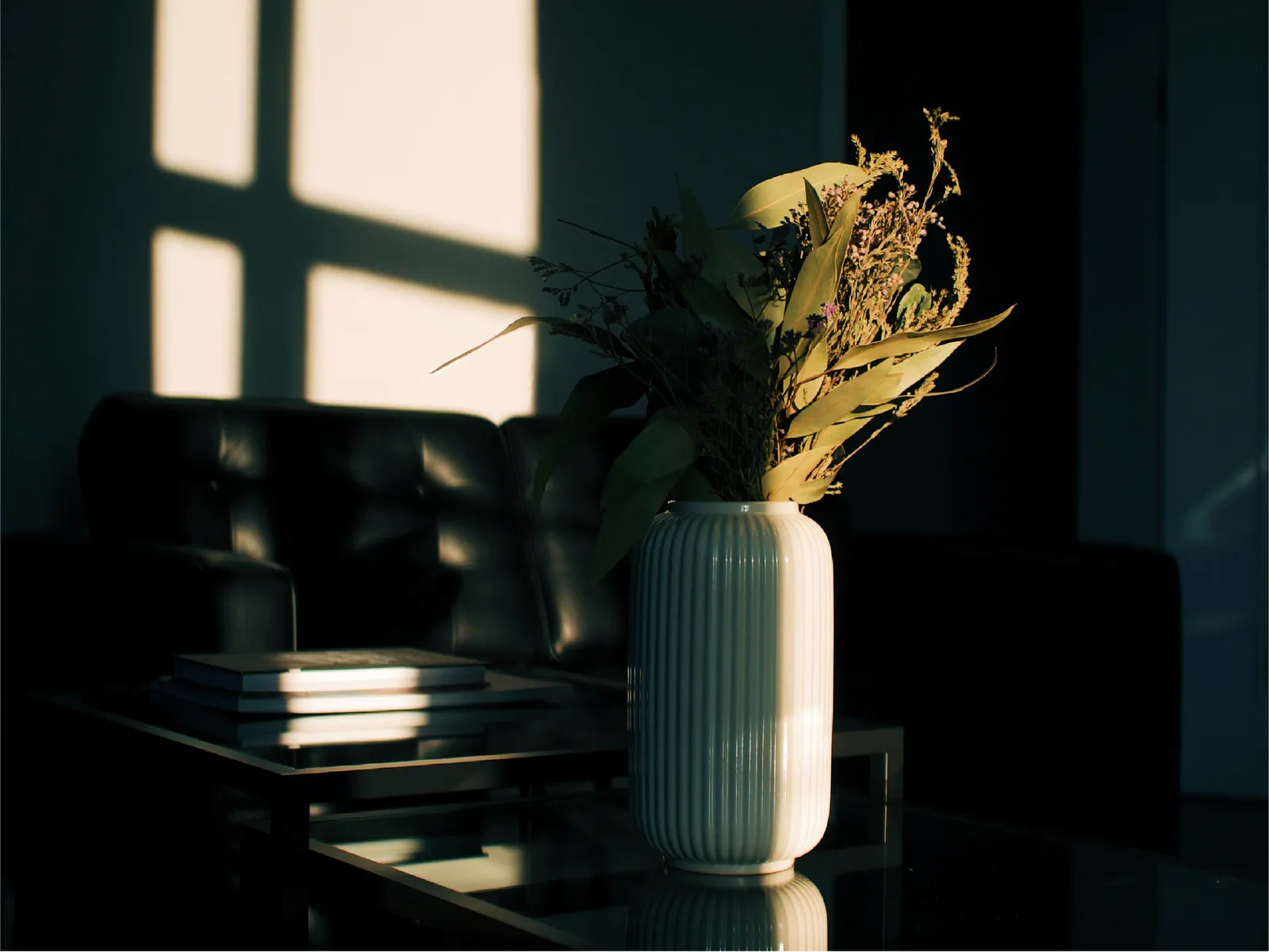 A vase of flowers in an office with dramatic lighting