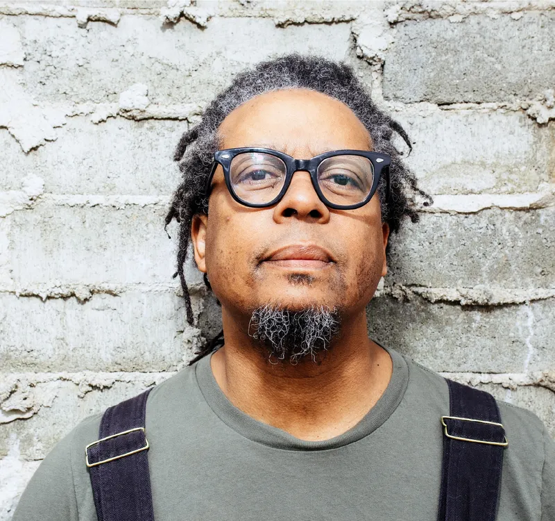 Jeff Parker smiling in front of a brick wall